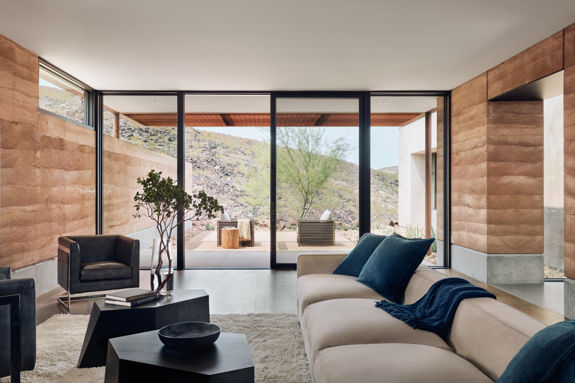 The rammed earth textures, colors and materials blend seamlessly with the surrounding desert.