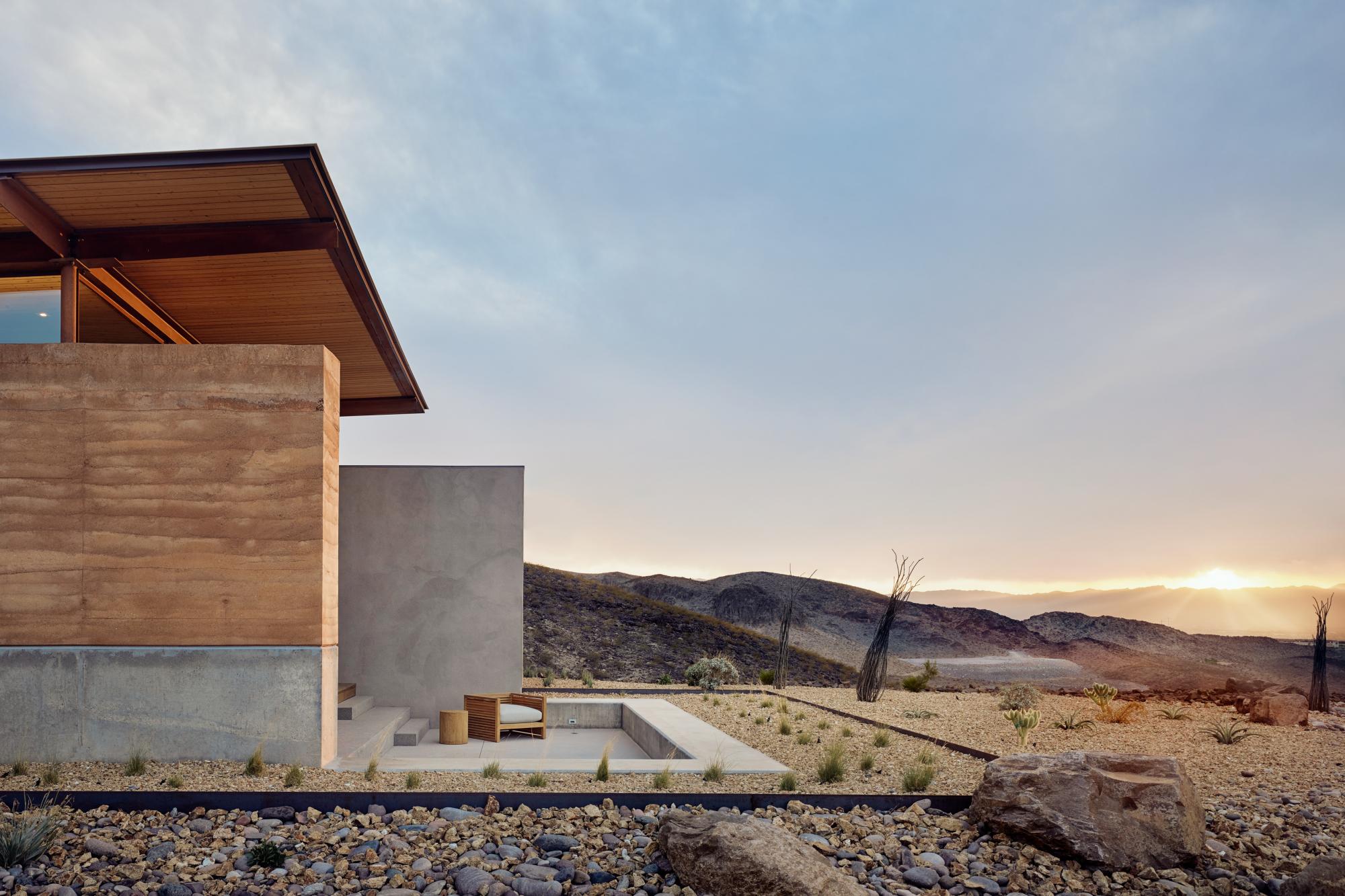 The rammed earth textures, colors and materials blend seamlessly with the surrounding desert.