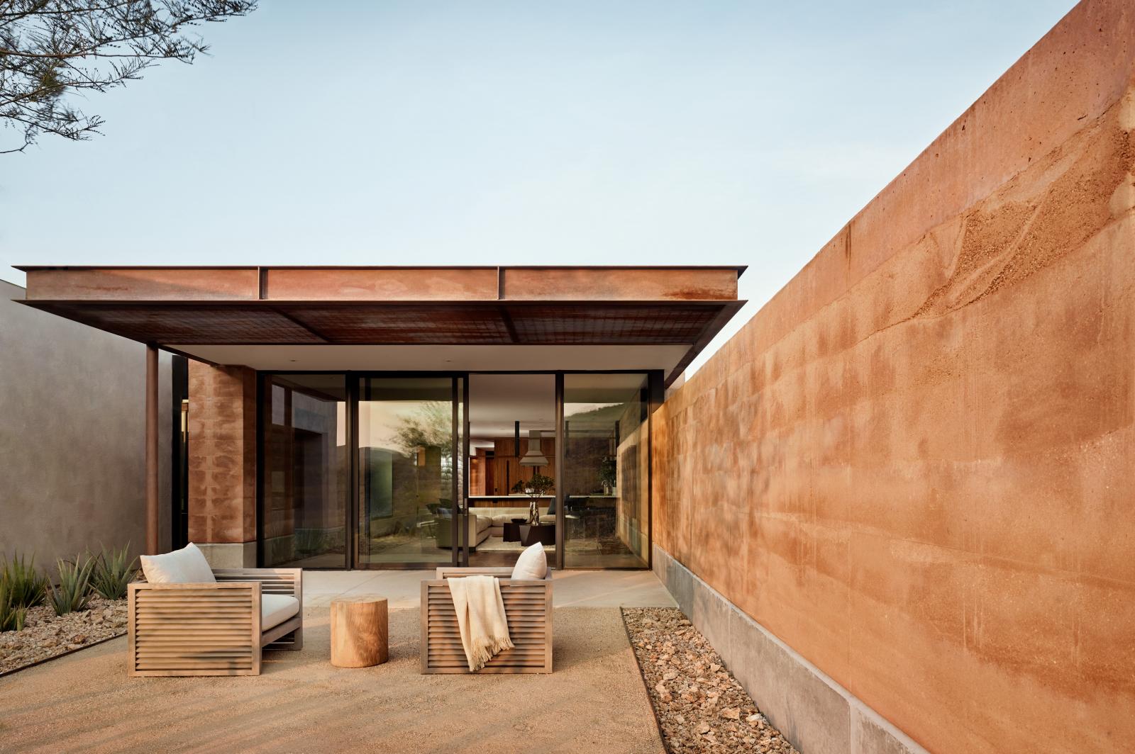 Rammed earth walls extend around the courtyard facing living area The rammed earth walls create outstretched wings that frame a private landscape while blocking the intense west exposure and northern winter winds.