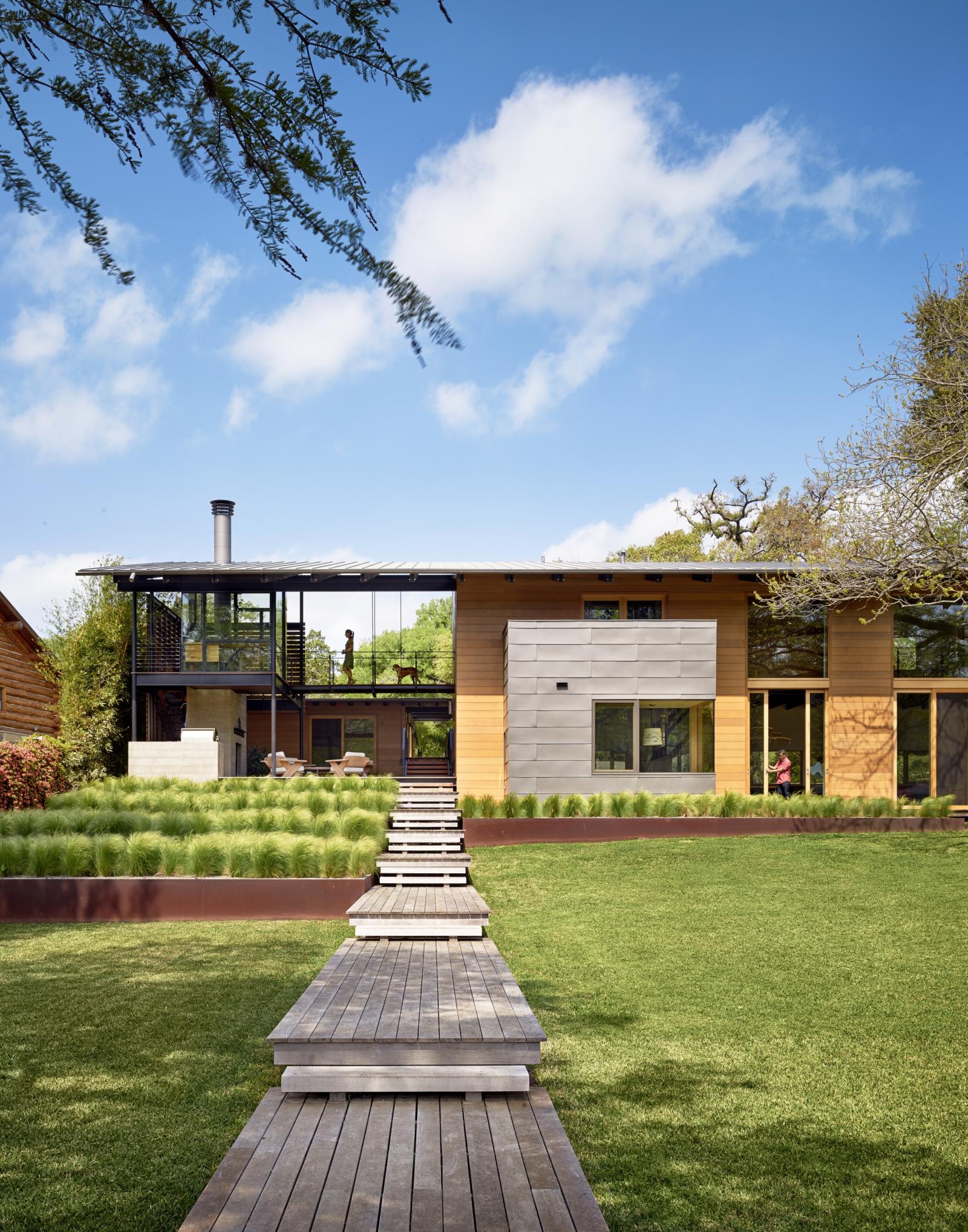 Situated at the confluence of Hog Pen Creek and Lake Austin, Hog Pen Creek Residence was envisioned by its owners as a place that evokes the playfulness of summer on the lake and emphasizes exterior living space. Towering heritage oak trees, a steeply slo