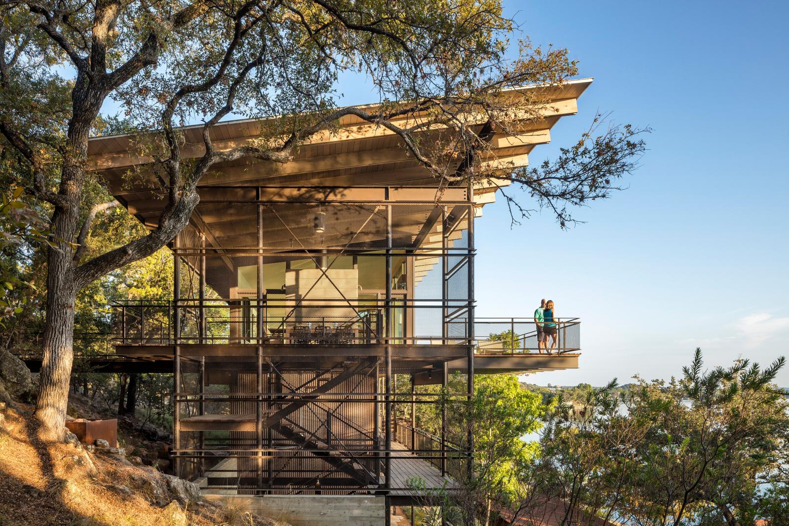 An award winning vertically structured lake house The long, narrow three-story residence dramatically culminates at the top floor, set just above the tree line and providing a nearly 180-degree view of the lake beyond