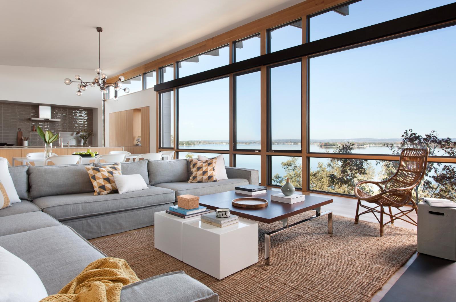 From the living room, the third floor north-facing glazed wall offers unobstructed views of the lake An award winning vertically structured lake house The long, narrow three-story residence dramatically culminates at the top floor, set just above the tree line and providing a nearly 180-degree view of the lake beyond