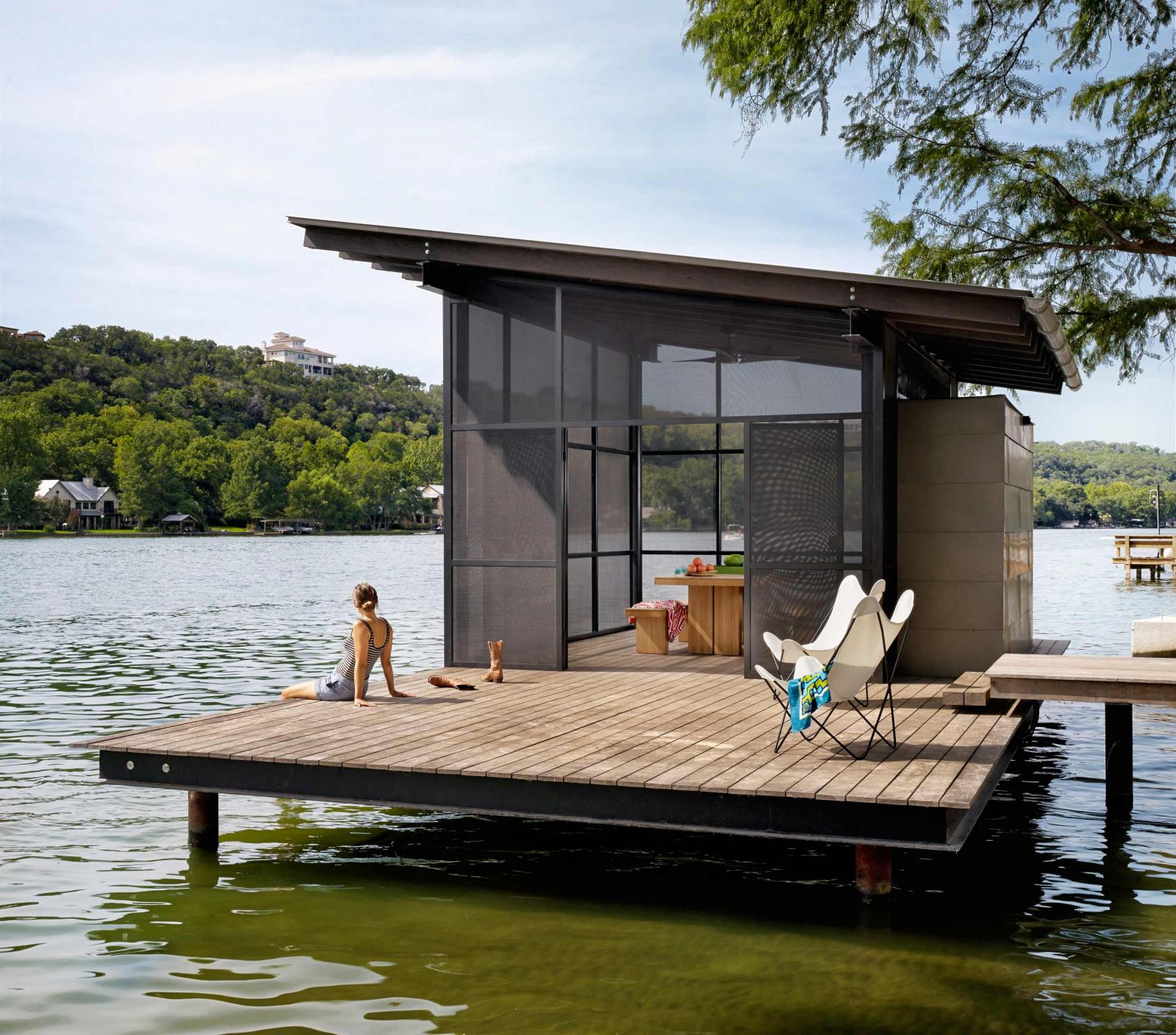 Lakeside screened pavilion with a woman relaxing feet in water Situated at the confluence of Hog Pen Creek and Lake Austin, a screened pavilion by the water’s edge provides a place that evokes the playfulness of summer on the lake.