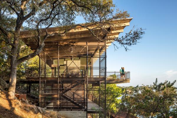 An award winning vertically structured lake house The long, narrow three-story residence dramatically culminates at the top floor, set just above the tree line and providing a nearly 180-degree view of the lake beyond